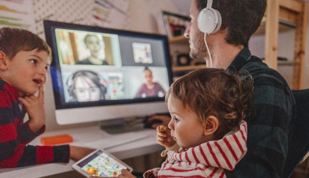 Father working from home with his 2 kids